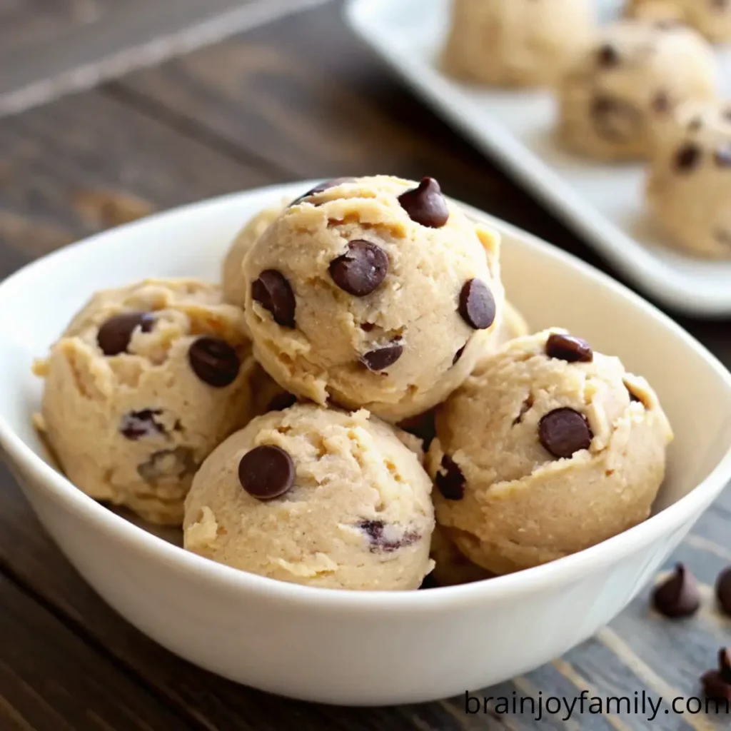 Boules de pâte à cookie crue aux pépites de chocolat servies dans un bol blanc – Recette Cookie Dough.